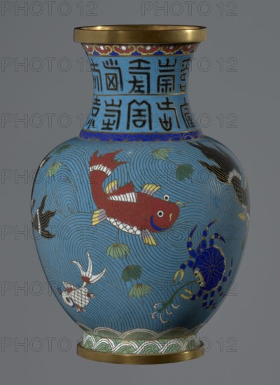 Vase, Chinese, Qing dynasty 1644–1911, 19th century. Cloisonné enamel vase on a foot with a neck; decoration of fish and crabs on a turquoise background and an archaizing inscription on the neck. Vessel, height 23.2 cm, diameter 9.1 cm., A rounded vase with a narrow neck and flared rim sits against a neutral background; the rim and foot have metallic gold bands, and the body is predominantly light blue with swirling wave patterns in darker blue lines. A large red fish with white and yellow fins is depicted on one side, accompanied by a smaller white fish and a dark blue crab with yellow accents; there are also a few green and pale yellow lotus leaves and other stylized aquatic plants. The neck area features a light blue band with dark vertical decorative characters, separated from the body by a narrow deep blue border with a repeating scallop motif, and the base has a green and white wave-border design. Overall visible colors include light blue, dark blue, red, white, yellow, green, bl...