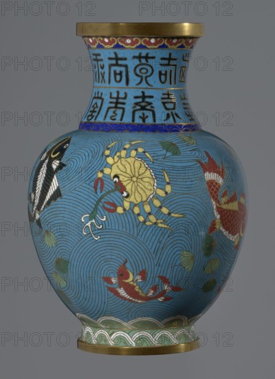 Vase, cloisonné enamel, 19th century, China Qing dynasty. Vessel on a foot with a neck; decoration of fish and crabs on a turquoise background and an archaizing inscription on the neck. Height 23.5 cm; diameter 9.3 cm., A rounded vase with a flared neck sits against a neutral background, predominantly covered in bright blue; the neck area shows a band with darker blue and black ornamental shapes, and the rim and base edges have metallic gold accents. The body features swirling wave-like line patterns in darker blue and is decorated with a group of stylized aquatic creatures including a yellow crab with red claws, several fish in red and white with gold detailing, and a black and white fish. There are also scattered green leaf-like motifs and bands of green and pale blue decorative patterns near the base. Overall visible colors include blue, yellow, red, black, white, green, metallic gold, and pale blue.