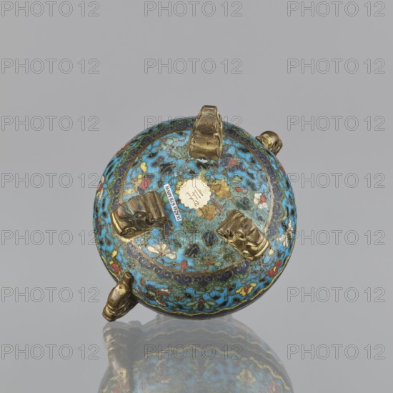 Ding incense burner, cloisonné enamel, floral motifs, butterflies, peonies, fantasy beasts; Ding incense burner on a tripod with two plastically shaped handles; no cover; floral decoration in striped arrangements; Qing dynasty 1644–1911, 18th century, China; vessel; height 8.4 cm, width 12.4 cm, diameter 9.8 cm., A round decorative object with a domed top sits against a plain light gray background and reflects faintly below; the object is primarily turquoise blue with patterns of darker blue, green, red, white, yellow, and black forming floral and abstract motifs, and it has several small metallic fittings in a dull gold color attached around its surface.