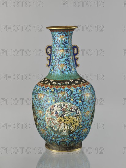 Vase, Chinese, Qing dynasty 1644–1911, 19th century. Cloisonné enamel vase with a neck; decoration: floral and plant tendrils on a turquoise background, birds and animals cranes, deer, tigers in circular medallions on a plant background, peonies, lotuses, chrysanthemums, zoomorphic motifs, meander and lotus tendril ornaments. Two stylized handles on the sides of the neck. Vessel. Height 33.0 cm; diameter 15.0 cm; weight 1.7 kg., A decorative vase with a bulbous body and a flared neck sits against a neutral gray background; the vase is predominantly turquoise and blue with accents of gold, black, green, red, white, and yellow, and features ornate scrolling floral patterns covering its surface. The neck displays stylized floral motifs in blue and gold on a turquoise ground and has a pair of symmetrical blue and gold applied handles. A band of black with small white floral elements encircles the shoulder, while the body is covered in intricate blue scrolling designs with gold highlights a...
