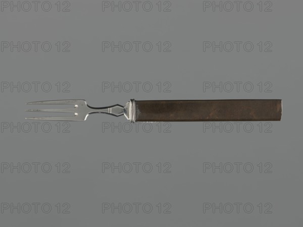 Fork with knife handle kozuka, Japanese, Edo period 1603–1868, 18th century; katana kozuka knife handle fashioned as a fork; materials for cutlery; height 16.9 cm, width 1.4 cm; melee weapon/sword accessory., A single fork with a metallic silver tined head and a dark brown rectangular handle is shown against a solid gray background; the fork head has three tines and a narrow curved neck with a small decorative collar where it meets the handle, and the handle appears slightly worn with subtle darker and lighter brown patches.