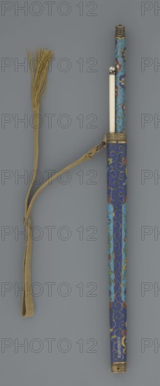 Travel cutlery set in case; Chinese, Qing dynasty 1644–1911, 19th century. a Knife with cloisonné enamel handle; steel blade. b–c Ivory chopsticks, with inlaid black lacquer ornament at the top in the form of a border. d File decorated similarly to the chopsticks. e Case of cloisonné enamel with bronze fittings engraved at top and bottom; interior lined with wood. Chopsticks and file held by a band decorated with a border; narrow cotton-silk strap with fringes attached. Case decorated with flowers in two reserves and plant tendrils in the background. Cutlery; plant motifs and swastika iconography; length 28 cm case., A long cylindrical object with a removable inner stick is shown alongside a braided cord ending in a tassel; the cylinder is decorated with swirling enamel patterns in shades of blue, turquoise, red, green, yellow, and gold, with metal fittings at its ends and at the midsection, while the inner stick is ivory-colored with a small decorative cap, and the cord and tassel are...