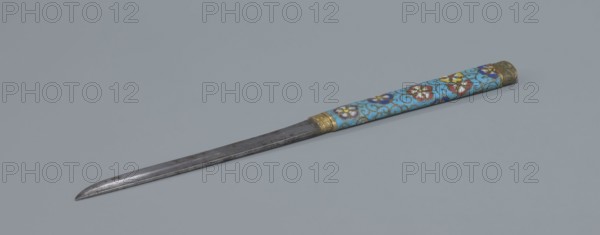 Travel cutlery set in case; 19th century China, Qing dynasty. Includes: a Knife with cloisonné enamel handle and steel blade. b–c Ivory chopsticks decorated at the top with an inlaid black lacquer border ornament. d File decorated similarly to the chopsticks. e Case made of cloisonné enamel with bronze fittings engraved at top and bottom; interior lined with wood. Chopsticks and file held by a band decorated with a matching border; narrow cotton-silk strap with fringes attached. Case decorated with flowers in two reserves and plant tendrils in the background. Plant motifs and swastika iconography. Cutlery; length 28 cm case., A slender metal blade with a pointed tip lies diagonally across a pale gray background, attached to a long cylindrical handle decorated with a turquoise blue surface patterned with floral motifs in red, white, purple, and yellow, and accented with gold-colored metal fittings at both ends.