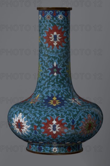 Vase, Chinese, Qing dynasty 2nd half of the 18th century. Cloisonné enamel vessel with a long, wide neck, supported on a separate ring-shaped foot and a flattened spherical belly. Main decoration: dense, multicolored lotus tendril covering the entire surface. Foot decorated with an ornamental band of small flowers and leaves. Upper edge of the neck at the rim decorated with a border of ruyi-head motifs. Neck ends with a thick, ungilded metal ring. Height 37.8 cm; diameter 15.5 cm., A tall bulbous vase with a long narrow neck decorated all over in a repeating floral and scrolling vine pattern in shades of blue, turquoise, teal, red, white, yellow, green, purple, and brown, featuring stylized multi-petaled flowers and leaf-like motifs on a gray background.