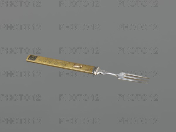 Fork with knife handle kozuka, Japanese, Edo period 1603–1868, 18th century, kozuka for a katana, made of metal cutlery, function: fork, subject includes flies, height 16.9 cm, width 1.7 cm., A narrow metallic fork with a silver-toned pronged end and a long rectangular handle is shown against a plain gray background; the handle is brass-colored with a slightly weathered surface, a few darker spots, and a small raised decorative element, and the transition between handle and fork features a silver-toned collar.