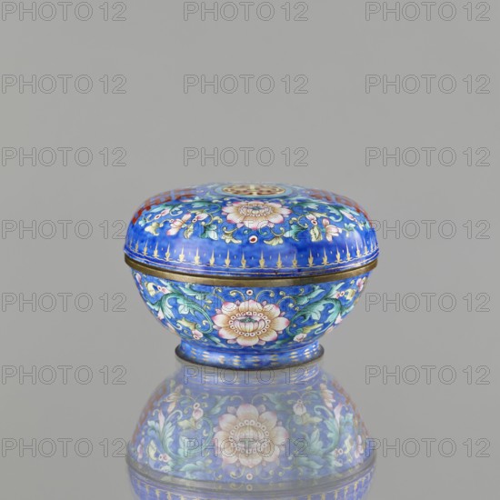 Incense burner — bowl with a lid; maker, Chinese; Qing dynasty 1644–1911; 18th/19th century; painted enamel on navy blue background; decoration includes bats, flowers peony tendril, coins, and the character shuangxi double happiness, usually used in marriage; ceremonial vessel/censer; height 6.4 cm, diameter 9.7 cm, weight 0.17 kg., A small rounded lidded box sits on a reflective surface against a plain light gray background, the box predominantly blue with accents of gold, green, pink, white, and red; the lid and body are covered in floral and foliate patterns featuring stylized pink and white flowers with green leaves, gold decorative lines and small red circular details, and a thin gold band at the seam between lid and base, the box’s colors and floral motifs mirrored in the reflection below.