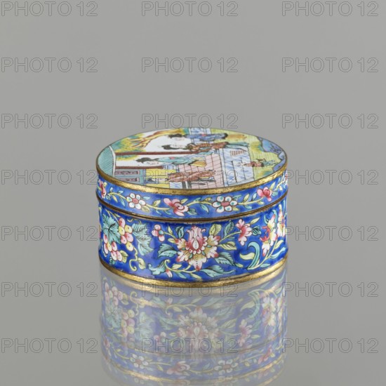 Box with a lid, painted enamel, Qing 1644–1911, 19th century, figurative scenes, peonies, grapes, peaches iconography, Chinese and Vietnamese Southeast Asian art/culture influences, Nguyen dynasty 1802–1945 associations, container; height 3.3 cm, diameter 6.3 cm., A small round box with a fitted lid sits on a reflective surface, showing a mirrored image beneath. The box is predominantly bright blue with gold trim and is decorated all around with floral motifs in pink, white, green, and pale yellow. The lid has a painted scene with figures and architectural elements in colors including pale blue, yellow, pink, green, and brown against the blue rim, and the overall palette includes shades of blue, gold, pink, green, white, yellow, and brown.