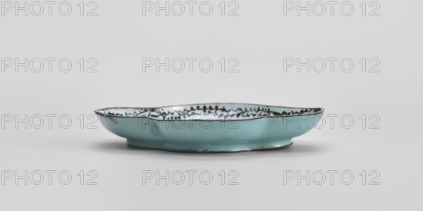 Plate, Chinese, painted enamel, Qing dynasty 1644–1911, 18th century, genre scenes, vessel, height 1.3 cm, width 7.5 cm, depth 9.1 cm., A shallow, round dish with a scalloped rim sits on a flat surface; the exterior surface is a muted turquoise blue and shows areas of darker edge wear in brown, while the interior rim has a patterned band in black against a pale background and the dish interior appears pale with subtle dark markings; the background and surface are light gray and the dish casts a soft shadow beneath it.