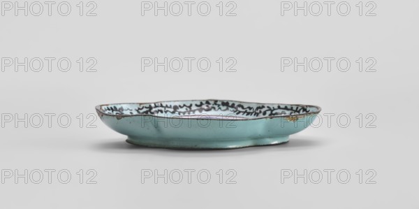 Plate, Chinese, Qing 1644–1911, 18th century, painted enamel depicting genre scenes, vessel; height 1.3 cm, width 7.5 cm, depth 9.1 cm., A shallow, oval dish with a scalloped rim glazed in pale turquoise on the exterior and interior, showing a decorative dark pattern along the inner rim; the rim and foot have darker brown edging and small areas where the glaze is worn or chipped, revealing a warmer, yellowish-brown beneath; the dish sits on a short circular foot and is photographed against a light gray background.
