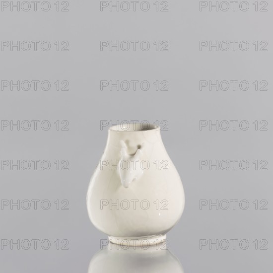 Vase, Chinese, porcelain blanc de Chine, decorative vessel, Qing 1644–1911, 2nd quarter of the 17th century, China, vessel; height 6.7 cm, diameter 5.8 cm, A glossy pale white ceramic vase with a bulbous body and a narrower neck sits centered against a smooth light gray background, showing subtle surface crackle and reflections; a small sculpted animal head projects from the front of the vase, and the vase rests on a slightly raised circular base with its reflection visible on the shiny surface beneath; visible colors include pale white, off-white, and light gray.