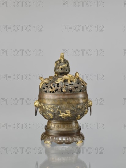 Censer with a cover on a base, maker, Qing style, Chinese art, Chinese culture; ceremonial/ritual vessel, censer with a high foot. Openwork cover and handles. Decoration: dragons and hôô phoenix birds on the cover; various animals tigers, birds, fish, phoenixes on the belly; dragon with a pearl, sea waves, clouds, geometric patterns, meander ornament. Cover with removable knob. 18th century, China. Dimensions: height 22.0 cm, width 21.0 cm, depth 17.7 cm., An ornate metal vessel sits on a rounded pedestal base, showing a mix of brown, bronze, and gold tones. The upper portion has a perforated domed lid with decorative cutouts and sculpted elements, including a finial at the top. A group of sculpted motifs, some raised and gilded, decorate the lid and shoulder, with curving, organic shapes and small animal-like forms. The body of the vessel displays a band of patterned engraving below the perforated section and a lower area with textured relief scenes and gilded decorative figures. Two ...