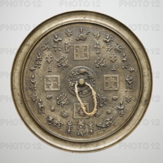 Mirror, gift, Chinese, Qing dynasty 1644–1911. Bronze mirror with polished obverse; reverse contains characters with good wishes and Chinese symbols for happiness associated with Taoism. 19th century. Mirror, diameter 34.5 cm, height 1.5 cm, weight 4.015 kg., A round metal mirror with a raised rim and a central boss, shown from above, with an attached braided loop of light beige cord; the mirror surface is an aged bronze color with darker brown areas and greenish patina; the surface is decorated with a ring of small raised figurative and abstract motifs including a few humanlike figures, a few animallike shapes, and a few knotlike designs arranged around the center, plus a few square framed panels containing raised shapes; the rim and outer edge have a slightly brighter golden-bronze tone while the decorative reliefs show varied brown and shadowed tones.