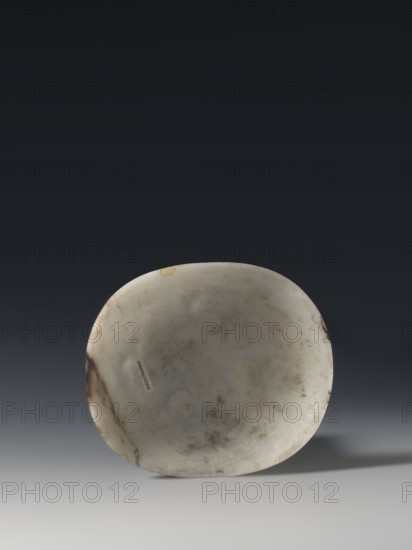 Convex plaque, Chinese, Taoism, Immortals iconography, Qing dynasty 1644–1911, white bluish jade, bas-relief, 19th century, China; plaque, height 12.0 cm, width 10.5 cm., A rounded, shallow stone object with a smooth surface showing mottled patches of off-white, gray, brown, and beige sits centered against a dark gradient background transitioning from deep charcoal to lighter gray toward the bottom, casting a soft shadow to the right.