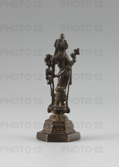 Bodhisattva, 10th century, Goryeo 918–1392, Korea, Chinese and Asian cultural influences, Chinese Buddhism, tutelary deities iconography, Korean art, Buddhist art; sculpture, figurine; height 11 cm; purchase, A small dark bronze figurine stands on a stepped base, showing a vertical human-like form with flowing drapery and raised arms; the surface has worn golden highlights and darker brown and black patina, and the base shows similar dark brown and gold wear.