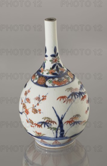 Bottle, porcelain, decorated with bamboos, pines, and plums the Three Friends of Winter, Imari palette, sake bottle tokkuri, ca. 1700–1730, Arita, Japan; height 22.3 cm, diameter 12.2 cm;, A rounded ceramic vase with a long narrow neck sits against a plain gray background; the vase is predominantly white with painted decorations in blue, red, green, and gold tones, including floral motifs and leafy branches that wrap around its body and neck, and a band of decorative patterns near the shoulder, with visible crazing in the glaze and a glossy surface that reflects onto the surface beneath it.