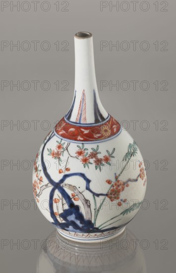 Bottle, early 18th century, Japan Edo, 1603–1868. Porcelain sake bottle decorated in the kakiemon style with a motif of the three friends of winter bamboo, plum, and pine; rock. Also features two borders with plant motifs and floral patterns on the neck. Height 22.1 cm; diameter 12 cm., A white ceramic vase with a long narrow neck and rounded body sits against a neutral gray background, decorated with floral and branch motifs in red, green, and blue, including red blossoms with green leaves and thin black branch lines, a band of red with floral scrollwork near the neck, and bold blue brushstrokes forming abstract shapes; the vase shows fine crackle texture in the glaze and a faint reflection beneath it on the surface.