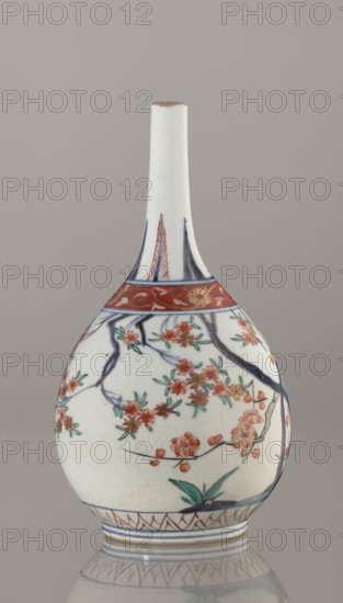 Bottle, Japanese, Edo 1603–1868, early 18th century. Porcelain sake bottle decorated in the kakiemon style with a motif of the three friends of winter bamboo, plum, and pine; rock. Also decorated with two borders with plant motifs and floral patterns on the neck. Materials: porcelain. Height 22.1 cm; diameter 12 cm., A pale ceramic bottle with a long narrow neck and a rounded body stands against a light gray background; the surface is predominantly white with painted decorations in red, blue, green, and brown, including a band of red with gold-toned floral motifs near the shoulder, dark blue branch-like lines extending over the body, and clusters of red and pink blossoms with green leaves scattered across the rounded surface, along with a small green plant near the base and decorative blue and red linear patterns encircling the foot.