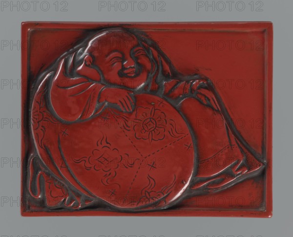 Box with a lid, Japanese art; Japanese, Edo period 1603–1868. The relief depicts the seated god of happiness Hotei. Carved red lacquer. 1st half of the 19th century Edo period, 1603–1868. Container; height 1.8 cm, width 8.6 cm, depth 6.6 cm., A carved rectangular panel showing a reclining figure with a rounded face and closed eyes, resting an arm on a large circular object decorated with floral motifs; the carving has smooth raised contours and recessed outlines, with visible tool marks and worn edges. The scene is rendered in a deep red color with darker red to almost black shading in the recesses and along the carved lines, and the background around the figure is uniformly red. The overall composition is centered on the figure and circular object, with curved drapery forms and flowing decorative patterns visible across the surface.