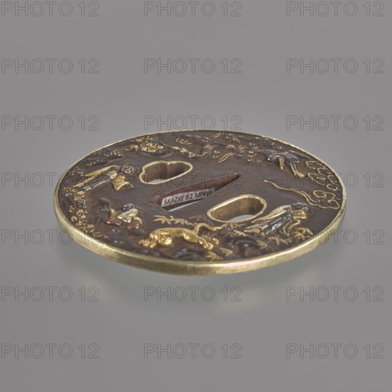 Crossguard tsuba, Sôten,  school author, Kitagawa, Sôten, / personal slogans /, Japanese art, Japanese culture, Edo 1603-1868, sword crossguards, weapons, cold weapons, swords, katana, tsubas, bamboos, pines, animals, tigers zool., cranes iconographic, horses, sages, waves, round tsuba maru gata, brass edge shinchu fukurin, similarly edged side holes ryôhitsu ana. High relief decoration depicts Taoist immortal sages, animals - a tiger, a crane symbols of courage and longevity, plants - a pine tree, a bamboo, a tendril - and clouds., 18th century Edo period 1603-1868, Japan, Ômi Eshu province, tsuba, diameter 8 cm, thickness 0.4 cm, A round metal object with a raised rim, shown against a plain gray background, featuring a dark brown surface with gold and brass-colored decorative elements and accents; the object has a few irregularly shaped cutouts and a few raised relief figures and organic motifs in gold and brass tones on the brown field, with some lighter metallic highlights and subt...