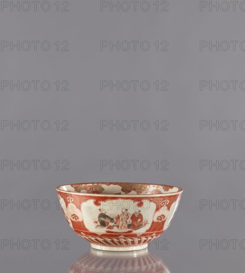 Bowl, Kutani, 19th century Edo period, Japan, Kaga. Porcelain vessel, height 8.8 cm, diameter 18.8 cm. Decoration: figural scenes, birds, flowers, plum trees, chrysanthemums; kacho flowers and birds, kachôga iconography., A shallow ceramic bowl with a rounded rim and a small foot sits centered on a reflective surface against a plain gray background; the bowl is primarily cream with prominent red-orange painted decoration forming borders and panels around the exterior, including cloud-like motifs and ornate scrollwork, and a few painted human figures depicted in seated poses inside one of the decorative panels; the interior rim shows additional red-orange ornament and the base has a band of vertical red-orange strokes visible in reflection.