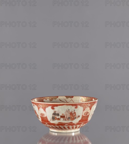 Bowl, Kutani, Japanese, Edo period 19th century, Kaga province. Porcelain vessel height 8.8 cm, diameter 18.8 cm with figural scenes and kacho motifs—birds, flowers, plum trees, chrysanthemums kacho/kachôga. Maker attribution/markings: role/classification of the creator, manufacture., A ceramic bowl sits against a plain gray background, showing a palette of red, white, cream, and gold tones. The exterior of the bowl features red borders and decorative red cloud-like panels on a cream base, with painted scenes in darker red and blackish-gray within the panels. The rim and interior upper edge display gold highlights, and the bowl rests on a short foot that is cream-colored with red decorative elements; a soft reflection of the bowl appears on the surface beneath it.