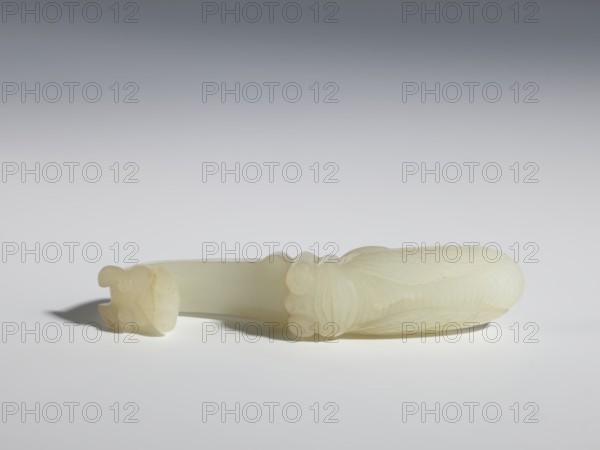 Belt clasp, Milky-white translucent jade. Chinese, Qing dynasty 1644–1911, 18th–19th century. Subject/iconography: cicadas and dragons. Shaft in flat relief; head carved in full relief. Belt buckle. Dimensions: height 2.4 cm, width 10.7 cm, depth 2.1 cm., A smooth, pale off-white carved object lies horizontally on a light surface against a gradient gray background, showing a rounded, elongated form with carved, curved ridges and decorative scroll-like ends, one end slightly separated and casting a soft shadow; the object displays translucent cream and ivory tones with subtle variations in shading.