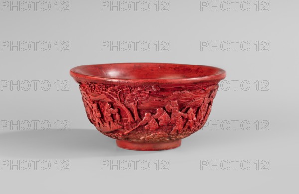 Bowl, figural scenes, Chinese art, landscape motifs, Chinese culture, Qing style, Qing 1644–1911, children, children's games, pine trees, fish, fishing, geometric-floral ornament, red lacquer, decoration carved in deep relief, 18th century China, vessel, height 7 cm, diameter 14.2 cm., A red carved bowl with a rounded rim and a short foot resting on a light gray surface, showing an intricate relief band depicting a group of figures and trees carved around its exterior; the bowl's interior and rim show variations of red with some darker red marks, and the carved exterior includes textured areas and shadows in deeper red tones against the lighter red highlights, all set against a pale gray background.