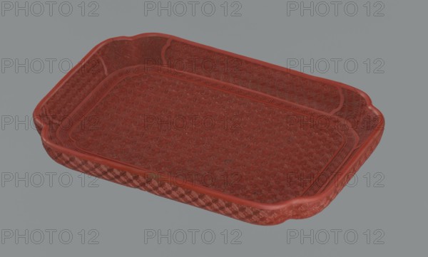 Tray, Qing dynasty 1644–1911, China; 18th–19th century. Porcelain vessel, height 2.0 cm, width 17.6 cm, depth 12.8 cm. Decorated with leiwen ornament, meander ornament, swastika iconography, kikko pattern, and geometric ornament., A shallow rectangular tray with rounded corners and raised edges, shown against a plain gray background; the tray has an intricate textured pattern across its bottom and inner sides, and a decorative border along the rim; the surface appears worn in places and the visible colors are shades of red and gray.