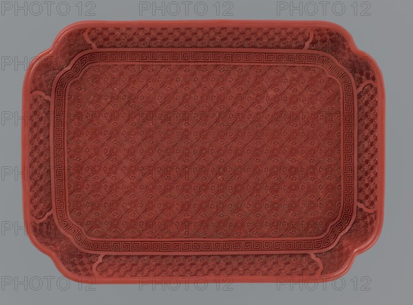 Tray, gift, Chinese, Qing 1644–1911, 18th–19th century, China, vessel; materials/ornament: meander, leiwen, kikko, swastika, geometric; height 2.0 cm, width 17.6 cm, depth 12.8 cm., A rectangular tray with rounded notched corners, shown from above, featuring an intricate raised geometric pattern across its surface and a decorative raised border; the tray is primarily red against a gray background, with visible shading giving darker and lighter red tones.