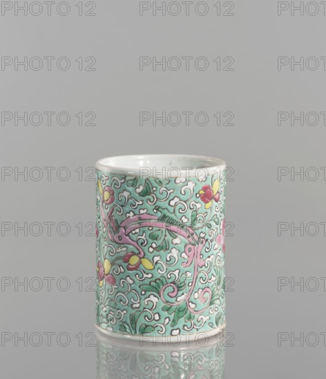 Brush vessel; Chinese; Qing dynasty 1644–1911; 19th century. Porcelain fragment with celadon glaze, decorated with painted overglaze enamel paints depicting floral tendril and dragon iconography. Cylindrical brush vessel. Height: 12.1 cm; diameter: 9.6 cm; weight: 0.5 kg., A cylindrical ceramic cup with a pale turquoise background covered in an intricate scrolling floral pattern in white, pink, green, and yellow, with a few rounded flowers in pink and yellow and curving vine-like motifs, a glossy white interior, and a pale rim, shown against a neutral gray background with a subtle reflection beneath.