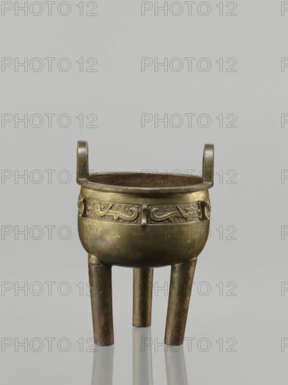 Ding incense burner, leiwen ornament, Ding vessel, ritual/ceremonial vessel with bird decorative motif and meander ornament, Chinese, Qing dynasty 1644–1911, 19th century, China; height 19.2 cm, diameter 13.6 cm;, A small bronze vessel with a rounded body and a band of low relief decoration around its upper circumference sits on three straight legs and has a pair of short, upright handles opposite each other; the bronze surface shows areas of darker patina and lighter golden tones with traces of brown and greenish discoloration, and the interior appears darker with mottled brown and green hues, all set against a plain pale gray background.