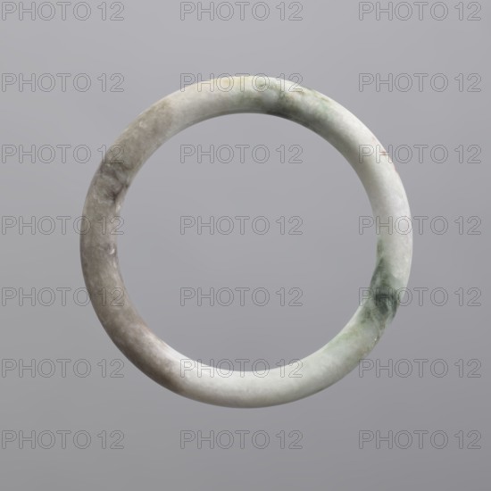 Bracelet, Chinese, Qing 1644–1911, women's jewelry, milky-white jadeite, opaque with green pigments, 19th century, China, jewelry, diameter 7.0 cm, A smooth circular stone ring suspended against a plain background, showing a mottled surface with shades of pale gray, white, light green, and faint beige, with subtle cloudy textures and polished highlights.