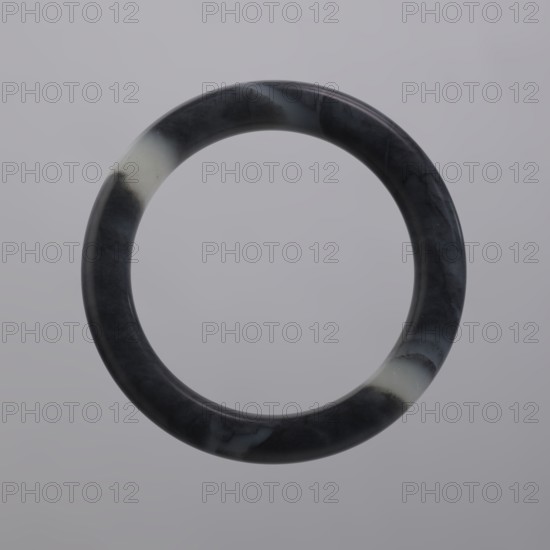 Bracelet, Chinese culture, Chinese art, Qing 1644–1911, women's jewelry, gray jade, dark colored, 19th century, China, jewelry, diameter 8.5 cm, A smooth circular ring with a marbled surface floating against a soft gray background, showing a mix of dark gray, black, and pale off-white areas with subtle veining and gentle highlights.