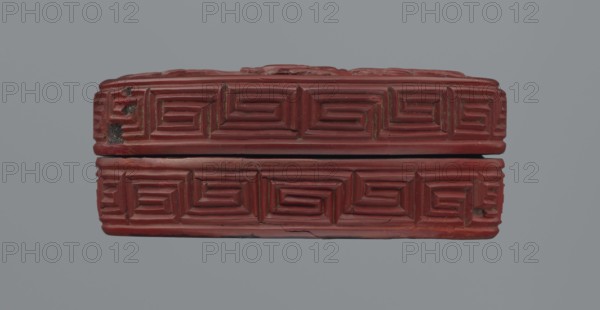 Box with lid, ; Chinese; Chinese Buddhism; Qing dynasty 1644–1911; 19th century; red lacquer with carved pattern featuring reeds, meander leiwen ornament, clouds, and Buddhist motifs; vessel with lid: height 2.3 cm, diameter 8.8 cm a; height 3.5 cm, diameter 8.9 cm, base: height 1.8 cm, diameter 8.8 cm b; box: height 3.1 cm., A rectangular carved object with a repeating stepped geometric pattern across its visible surfaces, shown as two stacked halves separated by a narrow horizontal gap; the surface is predominantly deep red with areas of darker red and small patches of black and brown where the material appears worn or chipped, and a muted gray background fills the surrounding space.