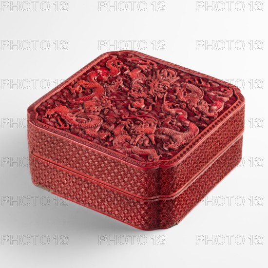 Box with a lid;, Chinese art; Qing dynasty 1644–1911, 18th century. Exterior covered with red lacquer stained with cinnabar; interior filled with black lacquer; decoration carved in deep relief. Rounded corners. Decoration: dragons dragon with a pearl, pearls, meander ornament, geometric-floral ornament, clouds. Vessel. Height 7.5 cm; width 17.7 cm; depth 17.5 cm., A square red lacquer box with rounded corners sits on a white surface; the lid features an intricate raised carving of swirling dragon figures and cloud-like motifs in deep red tones, while the sides display a repeating textured pattern in similar red shades with thin raised borders separating the two stacked tiers, and small areas of darker red and subtle shadowing emphasize the carved details.
