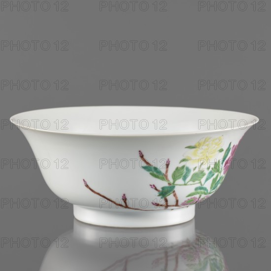 Bowl, Porcelain bowl with semicircular body widening toward the upper edge; white, transparent sintered glaze; decoration painted with overglaze enamel paints depicting peonies and floral decorations in colored porcelain. Chinese, Qing dynasty, Yongzheng period 1723–1735, 1723–1735. Vessel; height 7.6 cm, diameter 19.5 cm., A white porcelain bowl with a flared rim and a short foot, photographed against a gray background; the exterior shows a painted floral design featuring leaves in shades of green, flowers in yellow and pink, and brown branches with small pink buds, with the bowl's smooth glossy surface reflecting subtly below.