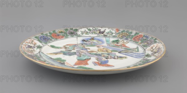 Plate. Porcelain fragment; white glaze. Decoration painted with overglaze enamel paints and iron red. Colored porcelain with plant motifs and figural scenes. Chinese, Qing dynasty 1644–1911, 18th century. Height 2.4 cm; diameter 20.4 cm; weight 0.35 kg., A shallow round porcelain dish viewed at an angle showing its decorated rim and interior, with a pale white background and gold trim along the edge; the rim is painted with a floral border featuring green foliage and flowers in red, pink, purple, yellow, and blue, and includes several small cloud-shaped panels containing bird and floral scenes in green, yellow, gray, and black; the central well shows a group of human figures wearing robes in colors such as turquoise, lavender, orange, blue, and yellow, arranged near stylized landscape elements in green and blue with a flowing drapery-like form in pale blue, and the painting includes fine line details in black and gray.