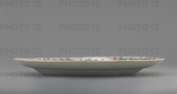 Plate. Porcelain fragment; white glaze. Decoration painted with overglaze enamel paints and iron red, featuring plant motifs and figural scenes. Chinese, Qing dynasty 1644–1911, 18th century. Colored porcelain. Vessel; height 2.4 cm, diameter 20.4 cm, weight 0.35 kg., A shallow ceramic plate photographed from the side, showing a narrow rim with a thin golden edge and a mostly white surface; the interior rim has a band of muted green and small areas of red and blue visible, while the underside and outer body appear light gray to off-white; the background is a smooth gradient of gray.