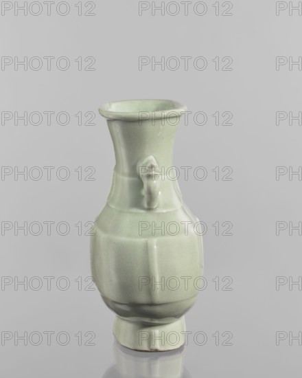 Vase, celadon glazed ceramic, Chinese, Qing dynasty, Qianlong period/style 1736–1795. Decoration with vertical, plastic, narrow stripes on the foot, body, and neck. Vessel; height 20.5 cm, width 16.4 cm, depth 6 cm., A pale green glazed ceramic vase with a glossy finish stands against a neutral gray background; the vase has a flared rim, a narrow neck with a small sculpted protrusion on one side, a rounded body with subtle vertical panels, and a slightly raised foot, showing smooth highlights and soft shadows in shades of pale green, light gray, and faint white reflections.