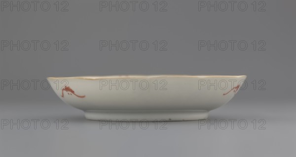 Plate. Chinese; Qing dynasty 1644–1911. Porcelain fragment with white glaze and decoration painted in overglaze enamel paints depicting cranes and waves. 19th century. Vessel; height 2.8 cm, diameter 13.5 cm, weight 0.15 kg., A shallow round ceramic dish with a scalloped rim sits on a flat surface; the dish is primarily white with a faint warm off-white tone and a thin golden trim along the rim, and it features a few small red decorative brushstroke motifs on its outer side; the background and surface are shades of gray.