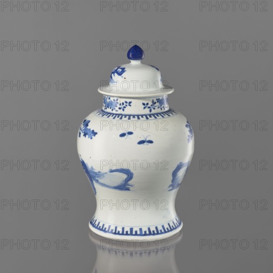 Vase with lid, Chinese, Chinese art, ceramics; motifs: boys, butterflies, female images, terraces architectural; thick porcelain body; greyish-blue glaze with underglaze cobalt painted decoration; 19th century, China; vessel, height 36.5 cm, A ceramic lidded jar with a glossy white surface and blue painted decoration sits against a neutral gray background; the jar has a bulbous body tapering to a narrower base and a domed lid topped with a blue finial, with floral and abstract blue motifs around the neck and shoulder, a band of geometric blue pattern near the base and rim, and reflections visible on the gray surface beneath the jar.