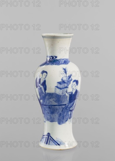Vase, figurative scenes, ceramics, Chinese art, Chinese culture, blue and white porcelain, terraces architectural motif, origin provenance: China, Qing 1644–1911 style; porcelain vase with transparent blue-gray glaze and underglaze cobalt painted decoration; 19th–20th century; vessel; height 24.3 cm, diameter 9 cm., A tall ceramic vase with a flared mouth and a gently curving body, decorated in blue on a white ground; the upper shoulder shows a band of painterly blue waves, the central body displays a scene of two seated figures in traditional dress facing a table with stacked boxes and a container holding long leaves or brushes, and flowing drapery painted in various shades of blue, while the lower foot area features a simple blue geometric and fan-like motif; visible colors include white and several tones of blue, with small areas of off-white or cream on the glazed surface.