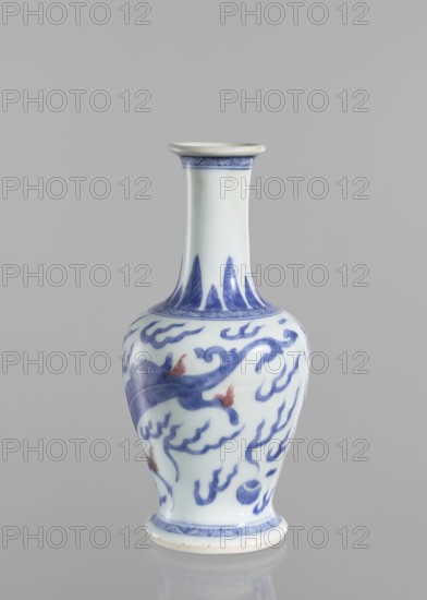 Vase, blue and white porcelain, Chinese art, Qing 1644–1911, 19th century, China; vessel with pearls and dragons iconography; height 19.6 cm, diameter 9.3 cm., A ceramic vase with a narrow neck and flared rim standing on a small round foot, predominantly white with blue painted decorative motifs and a few small areas of reddish-orange on the painted design, featuring flowing cloud-like patterns and stylized shapes; the background is a smooth neutral gray.