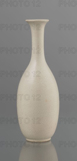 Vase on saucer. Vase made of stoneware or thick porcelain?, ovoid with a long cylindrical neck flaring at the spout. Light cream white matte glaze covered with fine cracklework. 19th century, Japan; ceramics; Edo 1603–1868 style; bottles. Height 24.1 cm; diameter 8.6 cm; weight 0.65 kg., A smooth ceramic vessel with an elongated, narrow neck flaring into a slightly wider mouth, tapering down to a rounded body and small base; the surface shows a network of fine crackle lines and a few tiny blemishes; visible colors include off-white or cream on the vessel and shades of gray in the background and reflected surface.