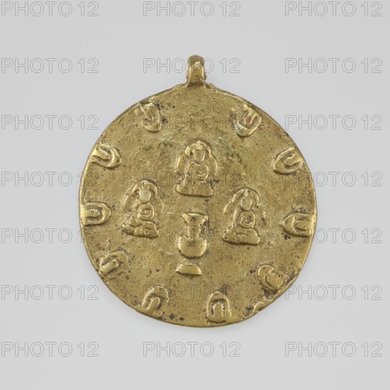 Amulet, 19th/20th century, Tibet; Tibetan Buddhist art; amulet with figural decorations; jug form; height 5.9 cm, diameter 5.2 cm., A round metallic pendant with a small loop at the top, shown against a pale gray background, its surface is a worn gold color with darker speckled areas and slight greenish tarnish; the pendant bears several raised stylized human-like figures arranged in a grouping near the center and a few curved crescent-like raised marks placed around the outer edge, all in the same gold tone with subtle shadows creating low relief.