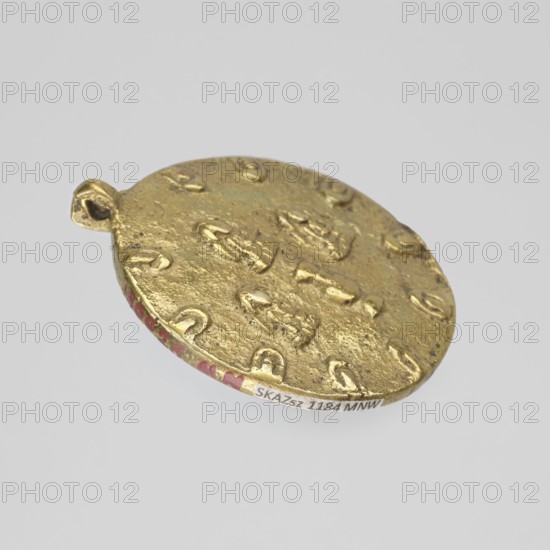 Amulet, Buddhist Tibetan art, figural decorations, 19th/20th century, Tibet; amulet, height 5.9 cm, diameter 5.2 cm., A round metallic pendant with a textured, uneven surface in gold tones is shown against a pale gray background; the pendant has a small loop for hanging and a scalloped edge with a few areas of red paint along the rim, and the gold surface features a repeated raised pattern of small curved and irregular shapes.