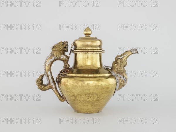 Teapot, Tibetan, 19th century, Lhasa. Jug with a lid on a chain; dragon-shaped handle, spout probably in the shape of a makara. Decorations: dragons, makaras, lotuses. Materials and technique: repoussé copper sheet, tin-plated inside, bronze-plated outside, patinated; silver-plated in sections. Repoussé spout and handle in low relief with inlaid eyes and copper rivets. Cover topped with a lotus bud. Function: tea vessel/kettle/teapot. Dimensions: height 25.5 cm; width 31.0 cm; diameter 19.3 cm; weight 0.85 kg., A metallic vessel with a rounded body and a fitted lid sits against a plain light gray background; the vessel is mainly gold in color with areas of wear and subtle surface irregularities, and it has an ornate handle and spout each shaped like stylized animal heads with decorative curving forms and textured details in both gold and silvery tones, a short decorative chain connects the lid area to the handle, and the overall composition shows polished reflective surfaces alongside ...