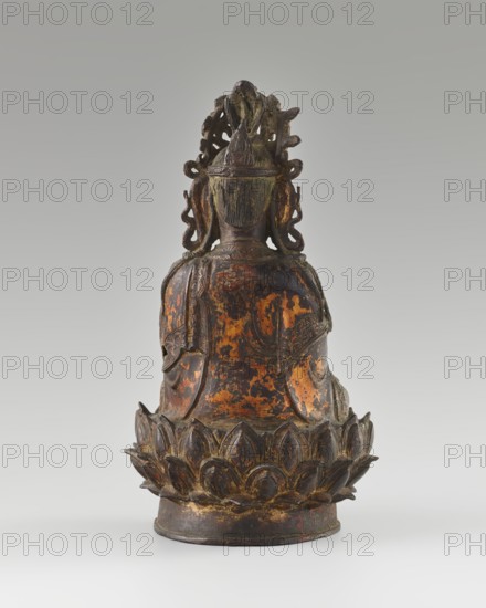 Guanyin; creator, Chinese; Qing dynasty 1644–1911, 18th century; sculpture; material not specified; height 24 cm; subject: bodhisattva Guanyin seated on a lotus throne; iconography: mercy; Buddhist art; Chinese Buddhism; figurine., A rear view of a seated figure carved from dark material with worn areas showing mottled patches of orange and brown, the figure wearing an ornate crown or headdress with swirling carved details and hair rendered in vertical striations, shoulders draped in a flowing garment with textured folds, and the figure seated on a stylized lotus base with layered petal shapes in dark brown and hints of gold and reddish wear against a pale gray gradient background.
