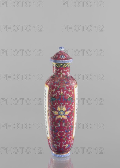 Vase with lid; Chinese; Qing dynasty, Qianlong period 1736–1795; colored porcelain; flattened vase form with lid; lotus tendril ornament; inscribed with poems/poetry; height 22.7 cm, width 10.7 cm, weight 0.65 kg., A tall, slender ceramic bottle with a domed lid stands against a plain light gray background; the bottle is predominantly deep red with ornate scrolling floral and foliate patterns in colors including yellow, blue, green, white, and pink, and it has decorative bands near the neck and base in blue and white; the lid echoes the red and multicolored floral motifs and is topped with a small rounded knob that shows blue and white; the bottle shows two vertical panels of a lighter color on opposite sides, each framed by a thin gold border, and the surface has a glossy finish that reflects light.
