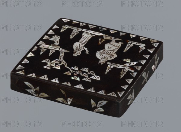Lid, made of black lacquer inlaid with mother-of-pearl, 19th century, Qing 1644–1911, China; figural scenes with trees and pines; height 1.7 cm, width 11.4 cm, depth 11.4 cm., A square, low-profile box with a dark brown to black glossy surface sits against a neutral gray background; the box top and sides show decorative inlaid pieces with an iridescent white to pearly sheen forming stylized plant motifs and triangular border accents, and the top surface also features two simplified humanlike silhouettes rendered in the same iridescent material positioned among branchlike shapes and clustered leaf forms.